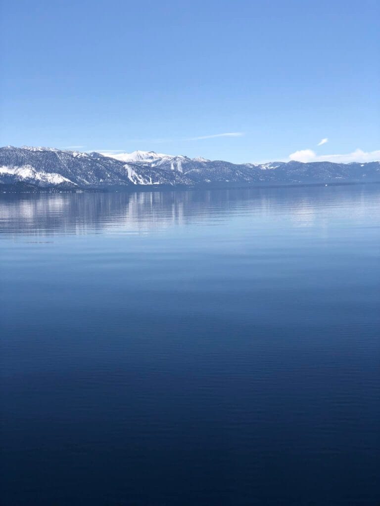Still waters of Lake Tahoe with mountain reflections on a calm afternoon