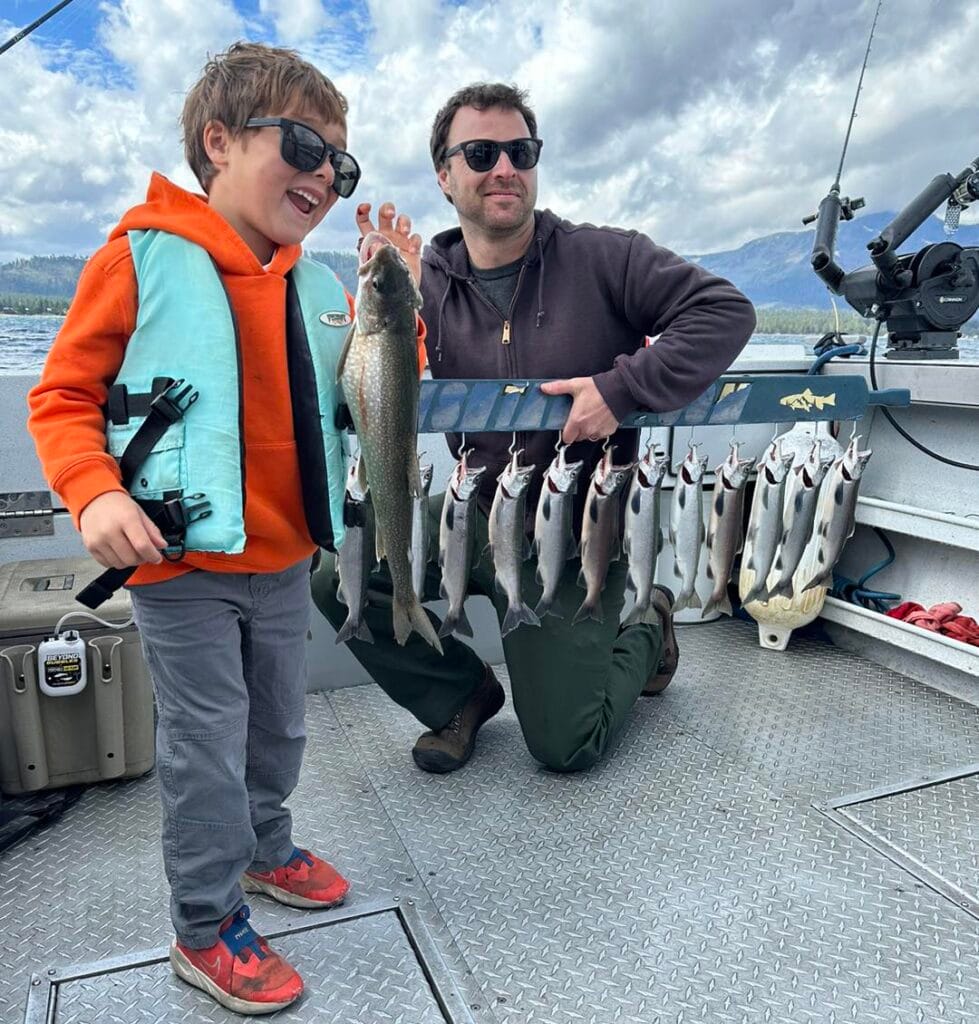 Young boy and father showing off Kokanee Salmon catch on Lake Tahoe