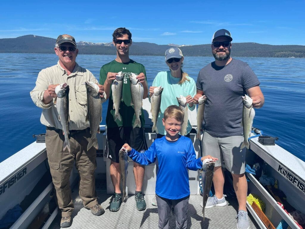 Family group holding Lake Tahoe trout on a fishing charter with FishTahoe.com
