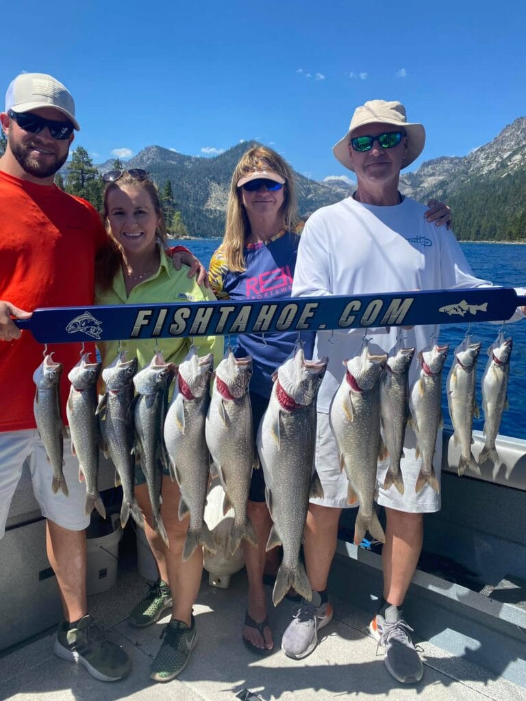 Smiling group with a full stringer of Lake Tahoe trout aboard a fishing charter