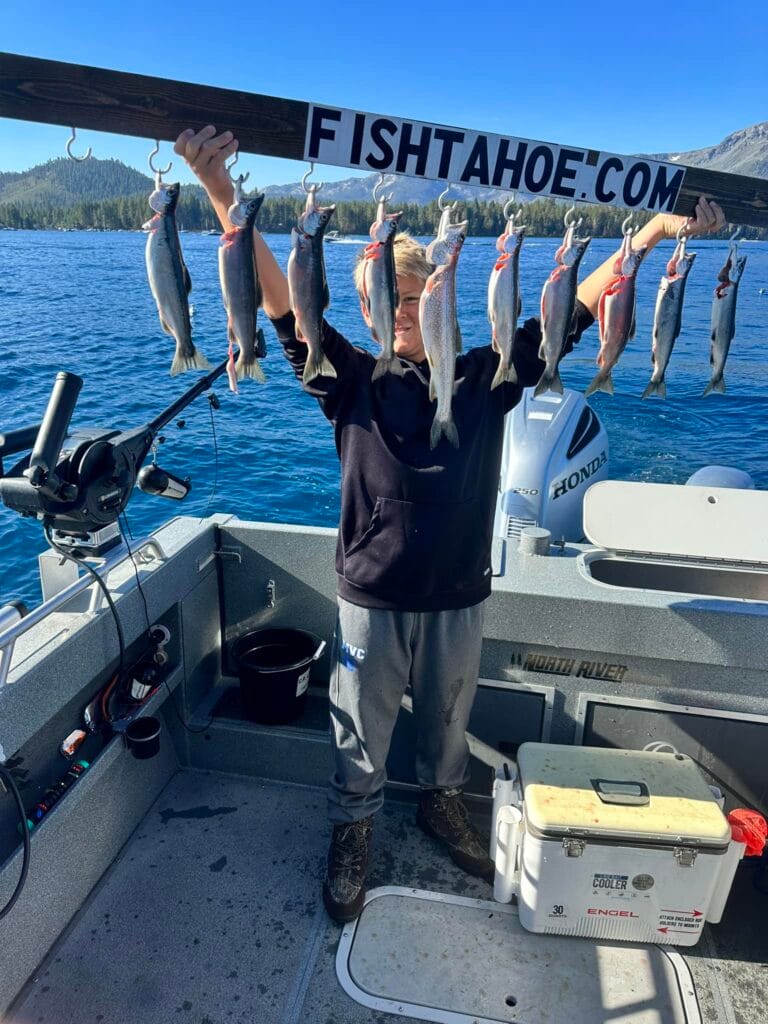Young boy holding stringer of Kokanee Salmon aboard FishTahoe.com charter boat