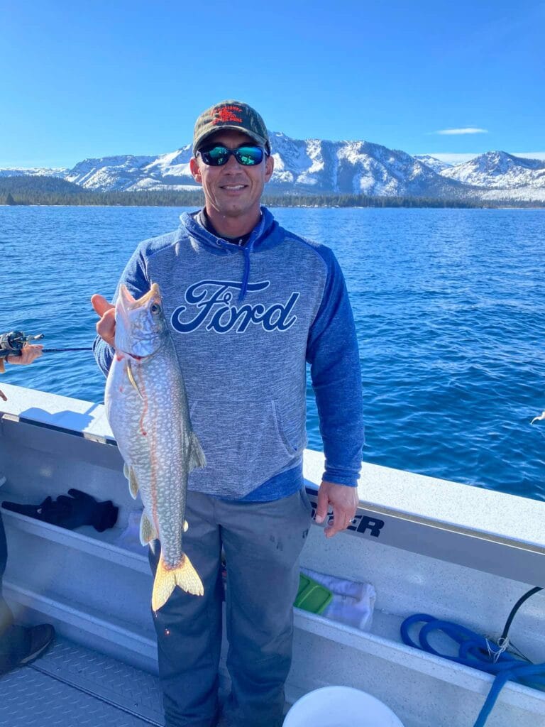 Angler holding Kokanee Salmon caught on Lake Tahoe fishing charter.