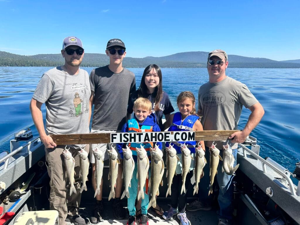Family displaying Lake Trout catch aboard FishTahoe.com charter in Lake Tahoe