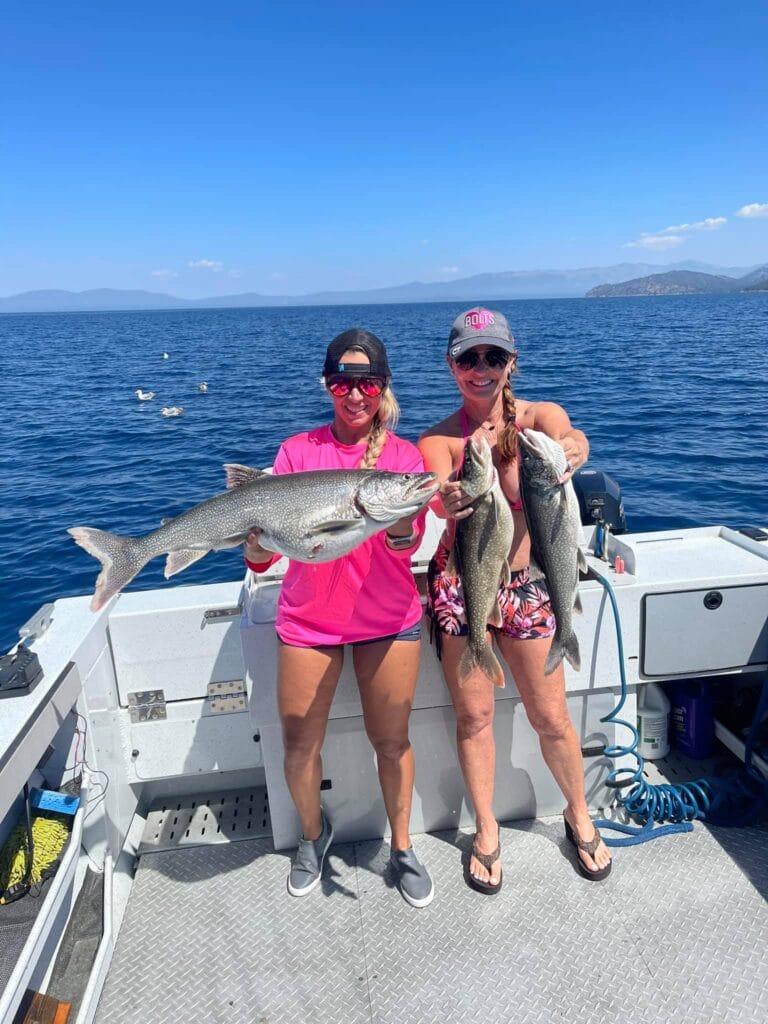 Two women showing off Lake Trout catches on Lake Tahoe fishing charter